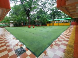 a tennis court in the middle of a park at Hill Forest Resort in Lonavala