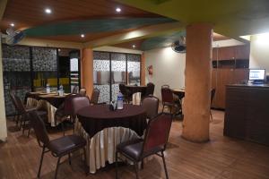 a restaurant with tables and chairs in a room at Hill Forest Resort in Lonavala