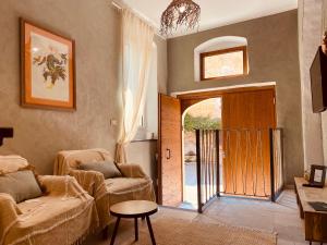 a living room with two chairs and a sliding door at Casa la meridiana in Laigueglia