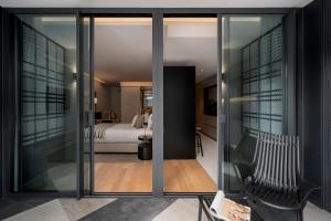 a room with sliding glass doors and a bedroom at Savoy Insular VI by An Island Apart in Funchal