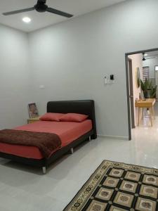 a bedroom with a bed with red pillows and a rug at Ruls Homestay Kuala Nerus in Kampong Banggol Setol +2 photos