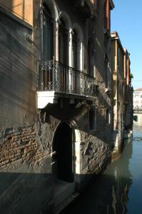 a building with a balcony on the side of a canal at Hotel Al Ponte Mocenigo in Venice