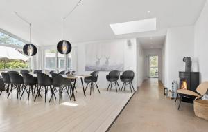 a dining room with a table and black chairs at Awesome Home In Ebeltoft With Sauna in Ebeltoft