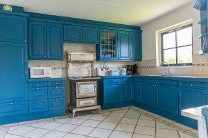 a blue kitchen with a stove and a sink at Buitenplaats 86 in Callantsoog