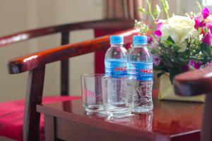 two bottles of water sitting on a table with a glass at Khách sạn Nậm Rốm in Diện Biên Phủ
