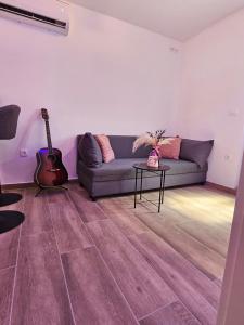 a living room with a couch and a guitar at Rita Apartments in Makarska +24 photos