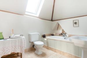 a bathroom with a toilet and a sink and a bath tub at The Clock Tower in Daventry