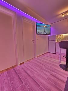 a room with a tv on the wall and a table at Rita Apartments in Makarska