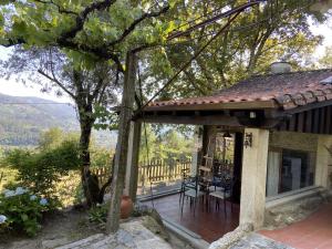 a porch of a house with a table and chairs at Quinta de Souto Velho in Terras de Bouro