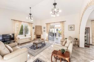 a living room with white furniture and a fireplace at Cliffside Villa in Tala