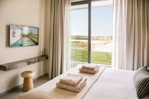 ein Schlafzimmer mit einem Bett, auf dem zwei Handtücher liegen in der Unterkunft Lora Pearl Luxury Villa in Protaras