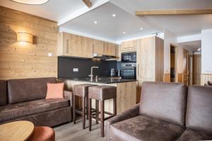 a living room with a couch and a bar at Résidence Les Balcons de Val Chavière in Val Thorens