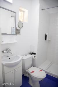 a white bathroom with a toilet and a sink at Hotel Iulia Resort in Venus