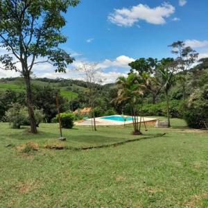 a yard with a swimming pool and trees at Granja Chácara Recanto do Vovô in Paula Lima