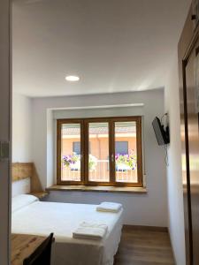 a bedroom with two beds and a window at Hostal San Juan in Sahagún