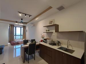 a kitchen with a counter top and a living room at Bali Melaka SeaView WaterPark 2-5Pax 5minJonker Projector in Melaka