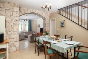 a dining room and living room with a table and chairs at Villa Stora kuća in Krapan
