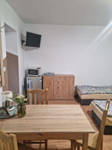a room with a table and a kitchen with beds at Agro nad jeziorem in Miastko