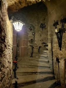 a stone hallway with stairs in a castle with lights at Burg Hermannstein - Rittersaal in Wetzlar +1 photo