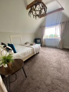 a bedroom with a bed and a table and a chandelier at The Ranch in Leitrim
