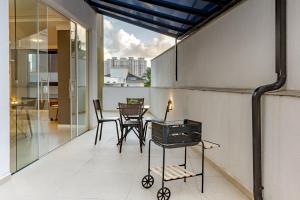 une pièce avec une table et des chaises sur un balcon dans l'établissement Ap c/ Terraço, 2 quadras da Praia em Itapema P1771, à Itapema