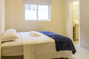 une chambre avec un lit avec deux serviettes dessus dans l'établissement Ap c/ Terraço, 2 quadras da Praia em Itapema P1771, à Itapema