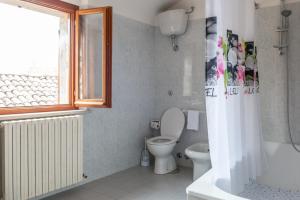 a bathroom with a toilet and a window and a tub at Casa Vacanze Francesca in Mondolfo +28 photos