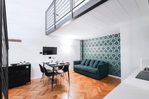 a living room with a blue couch and a table at Easylife - Studio a few steps from Duomo in Milan