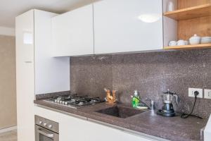 a kitchen with white cabinets and a stove top oven at Casa Vacanze Francesca in Mondolfo +23 photos