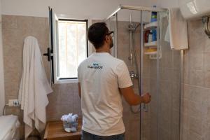 een man die in de douche in een badkamer staat bij Villetta Giardino dei Trulli in Ostuni +22 foto's