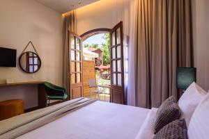 een hotelkamer met een bed en een balkon bij Arthur Suites in Old Town in Rhodos-stad