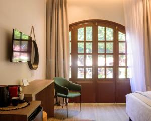 a living room with a door and a green chair at Arthur Suites in Old Town in Rhodes Town