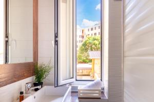 une salle de bain avec un lavabo et une grande fenêtre dans l'établissement TP Apartment Luxury Colosseum, à Rome
