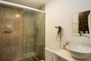 Un baño con ducha de cristal y lavabo. en Casa Container, 15 min da Praia no Campeche SUL91, en Florianópolis 11 fotos más