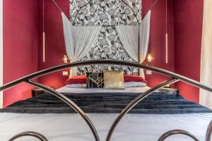 Cama en habitación con paredes rojas en ALE HOUSE, en Arezzo