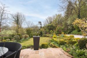 a garden with a table and chairs in the foreground at Oker Farm - Luxury farmhouse with hot tub in the Peak District in Matlock
