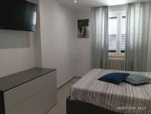 a bedroom with a bed with a dresser and a television at Tra cielo e mare in Capo dʼOrlando