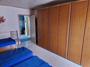 a bedroom with wooden cabinets and a bed and a chair at Casa Ulla am Hallenbad in Haiger