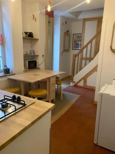 a kitchen with a stove and a table with a counter top at L'ARCADE in Louhans
