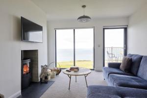 a living room with a blue couch and a fireplace at 2 Bed Penthouse Apartment - 14 in Nefyn