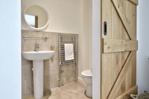 a bathroom with a sink and a toilet and a mirror at 2 Bed Penthouse Apartment - 14 in Nefyn +21 photos