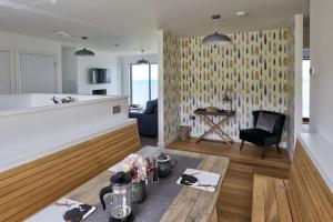 a kitchen and living room with a table and a couch at 2 Bed Penthouse Apartment - 14 in Nefyn