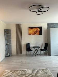 ein Wohnzimmer mit einem Tisch und zwei Stühlen in der Unterkunft Alexia apartment in Târgu Mureș