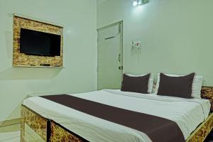 ein Schlafzimmer mit einem großen Bett und einem Flachbildfernseher in der Unterkunft Collection O The Mass Residency By Dv in Bangalore