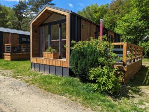 a cabin with a large window on the grass at Amira in Stuer +5 photos