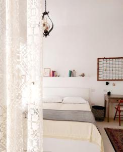 a bedroom with white walls and a bed with a curtain at Casa Vittoria Martina Franca in Martina Franca