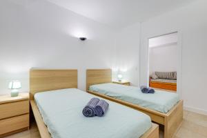 twee bedden in een slaapkamer met een spiegel bij Apartment with 2 bedrooms at Vilamoura Marina in Quarteira +45 foto's