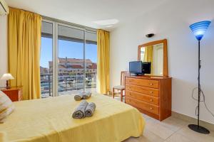 een slaapkamer met een bed en een groot raam bij Apartment with 2 bedrooms at Vilamoura Marina in Quarteira