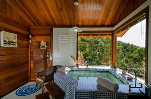 a house with a swimming pool in a room at Chalés Nó da Madeira in Visconde De Maua