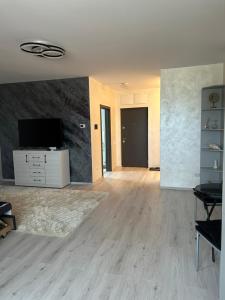 ein leeres Wohnzimmer mit einem Flachbildfernseher in der Unterkunft Alexia apartment in Târgu Mureș + 9 Fotos
